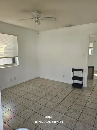 a view of a room with exposed radiator and ceiling fan