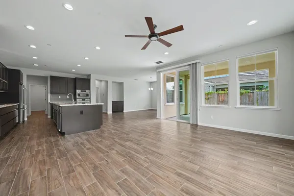 a kitchen with kitchen island granite countertop a sink stove and refrigerator