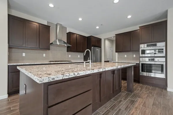a kitchen with granite countertop a sink a stove and a refrigerator