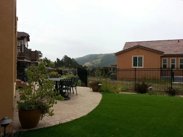 a backyard of a house with table and chairs