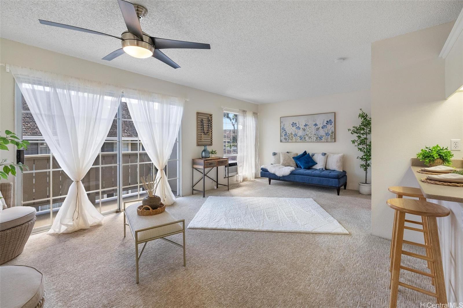 a living room with furniture a flat screen tv and a large window