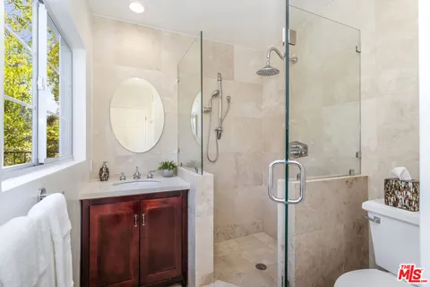 a bathroom with a mirror sink toilet and shower