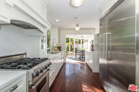a kitchen with sink stove and refrigerator