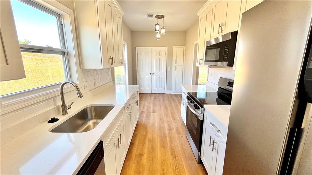 23 S Road Griffin, GA 30224 - Photo 10 of 32 a kitchen with a sink a counter top space stainless steel appliances a large window and a sink