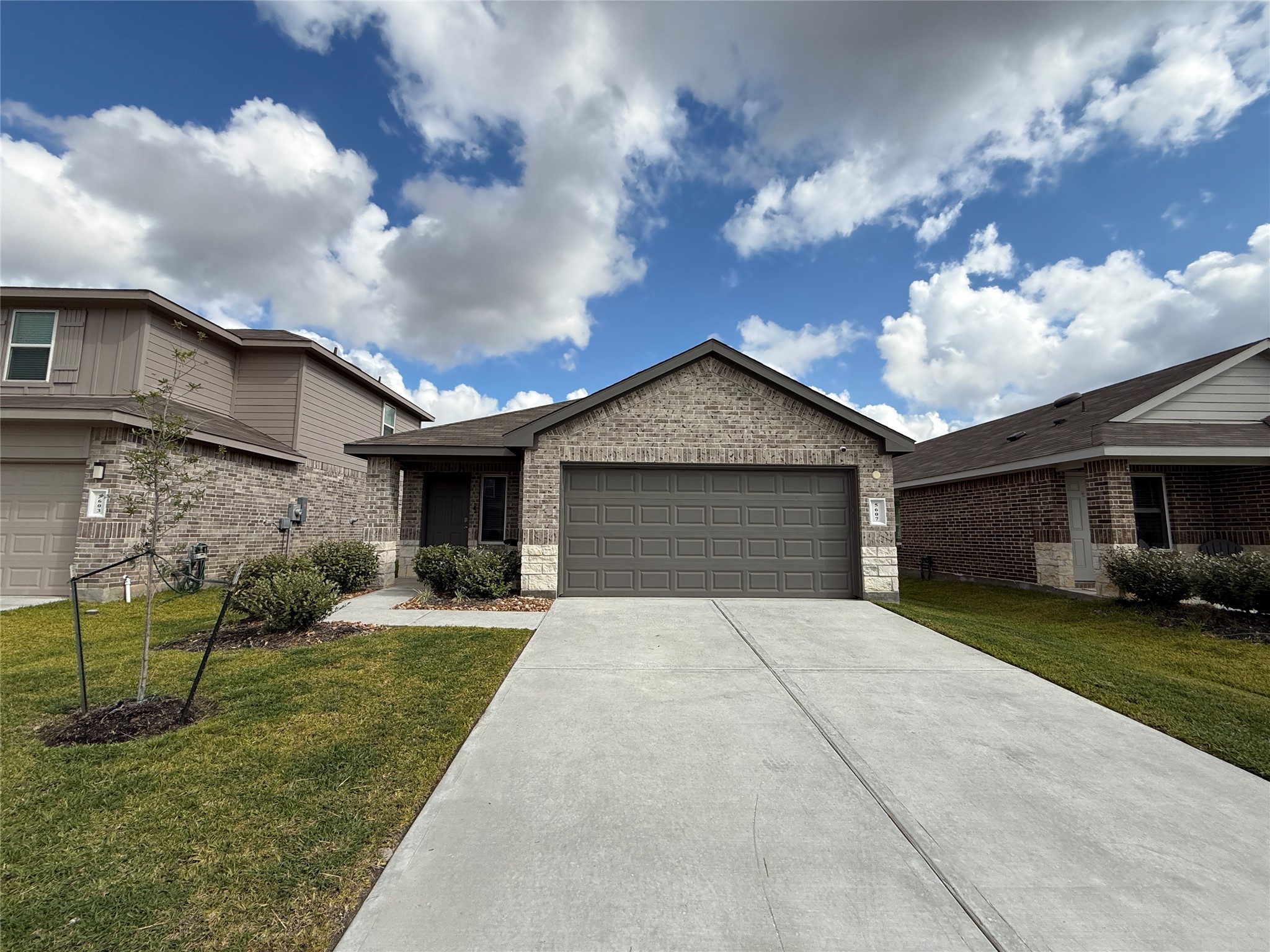 a front view of a house with a yard and garage