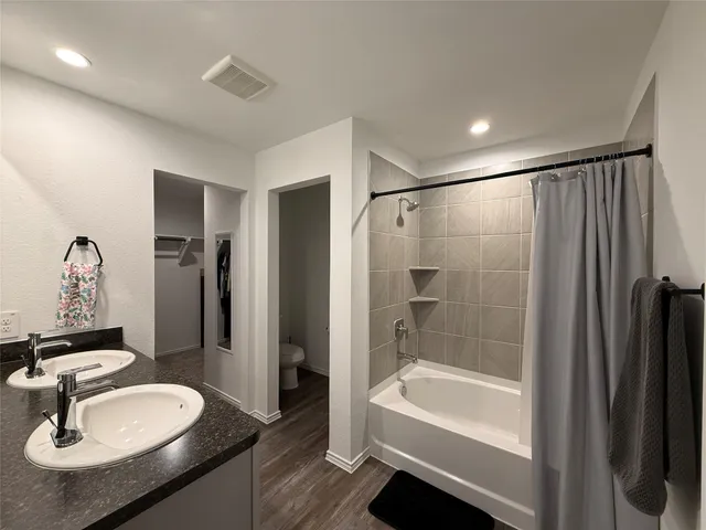a bathroom with a sink double vanity granite tub and shower