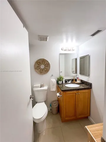 a view of bathroom with a toilet sink and mirror