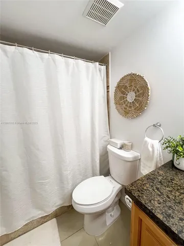 a white toilet sitting next to a shower curtain