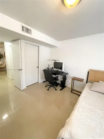 a bedroom with furniture and a air conditioner vent