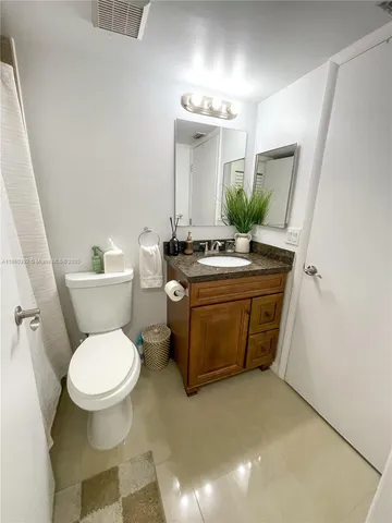 a bathroom with a sink toilet and mirror