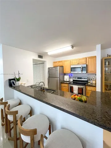 a kitchen with a sink and chairs