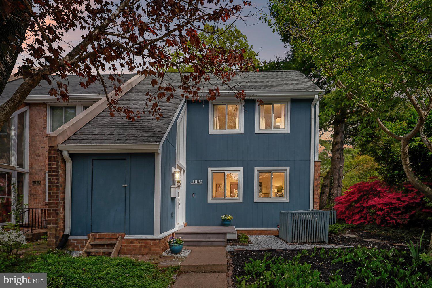 Charming blue home nestled among vibrant greenery.