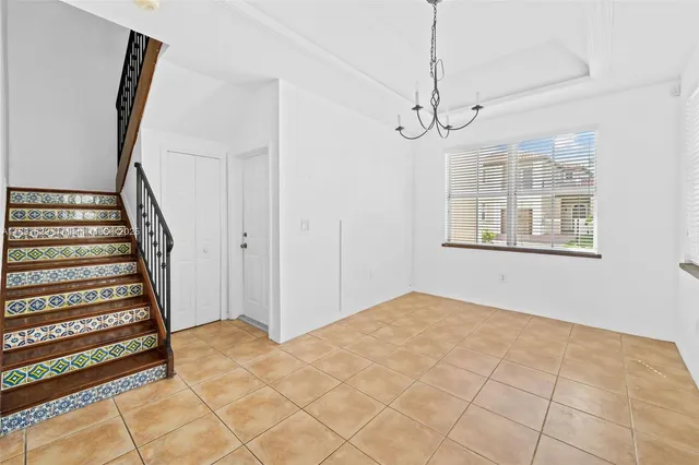 a view of an empty room with wooden floor and fan