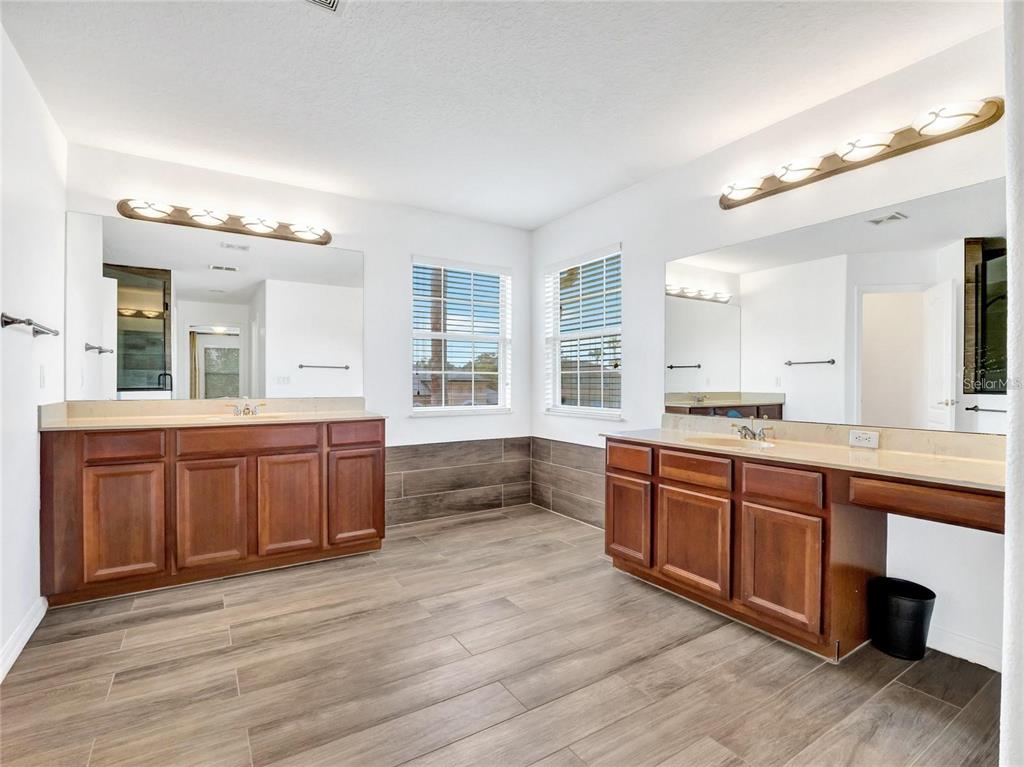 10023 Ians Ridge Road Orlando, FL 32832 - Photo 30 of 60 a large bathroom with double vanity and a large mirror
