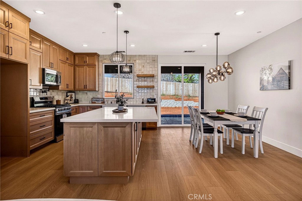 1528 Forest Paradise, CA 95969 - Photo 15 of 49 a kitchen with stainless steel appliances kitchen island granite countertop a sink a stove and a wooden floor