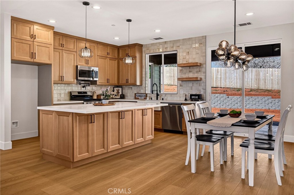 1528 Forest Paradise, CA 95969 - Photo 16 of 49 a kitchen with stainless steel appliances kitchen island granite countertop a stove a sink a refrigerator a center island and a wooden floor