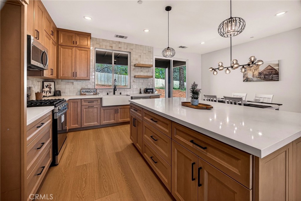 1528 Forest Paradise, CA 95969 - Photo 18 of 49 a large kitchen with a large island in the center and stainless steel appliances