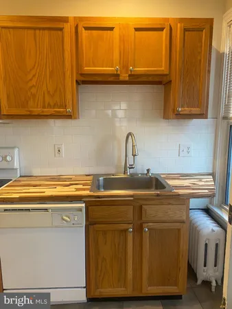 a kitchen with stainless steel appliances granite countertop a sink dishwasher a stove and white cabinets with wooden floor