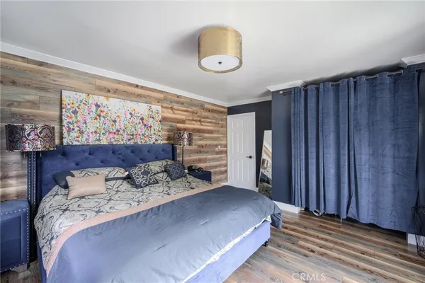 a bedroom with a bed and a painting on the wall