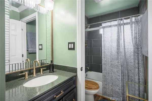a bathroom with a granite countertop sink toilet and shower