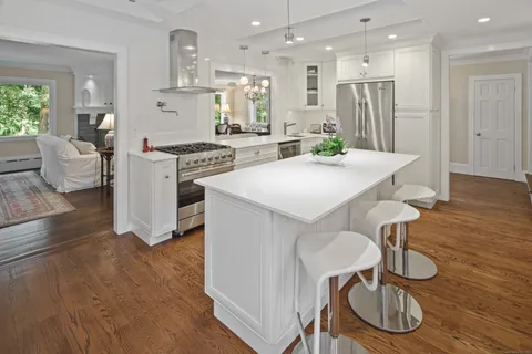 a kitchen with kitchen island wooden floor dining table and chairs