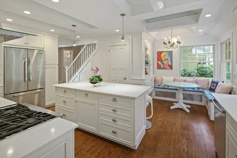 a kitchen with a sink appliances and wooden floor