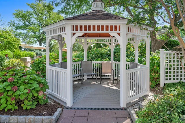 a view of a wooden house with a small yard and wooden fence