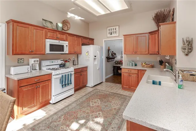 a kitchen with stainless steel appliances granite countertop a sink stove refrigerator and cabinets
