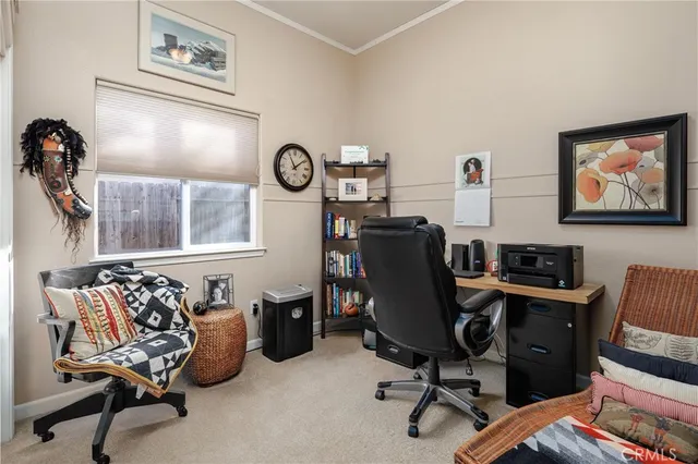 a view of a workspace with furniture and a window
