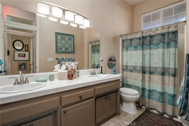 a bathroom with a double vanity sink toilet and shower