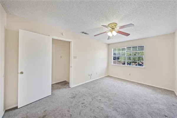 a view of room with a ceiling fan and a window