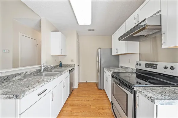 a kitchen with granite countertop a sink and a stove
