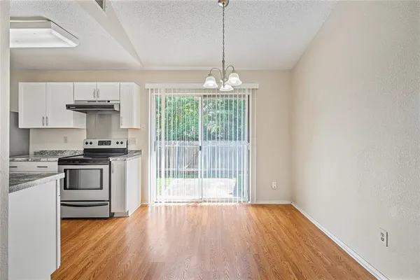 a kitchen with granite countertop a stove and a wooden floors