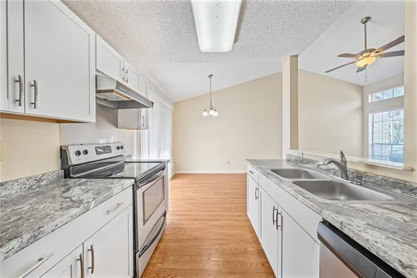 a kitchen with granite countertop a sink and a stove