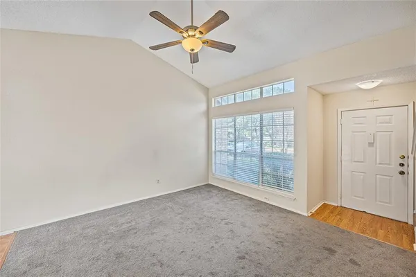 an empty room with a window and a fan