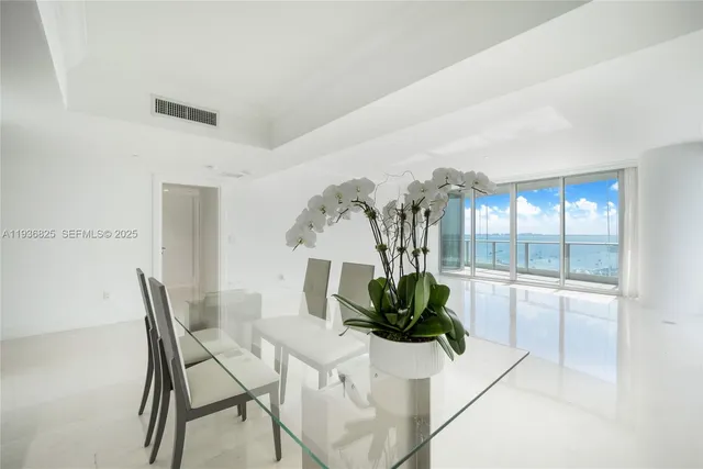 a dining room with furniture and large windows