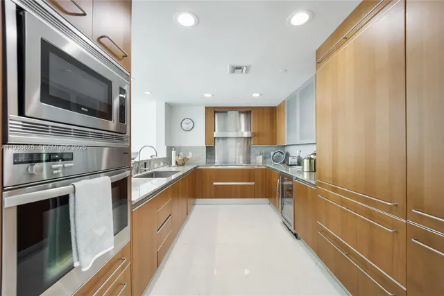 a kitchen with stainless steel appliances granite countertop a sink and a stove top oven