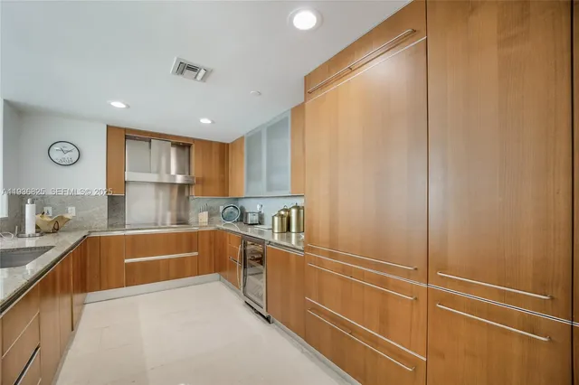a kitchen with granite countertop a refrigerator and cabinets