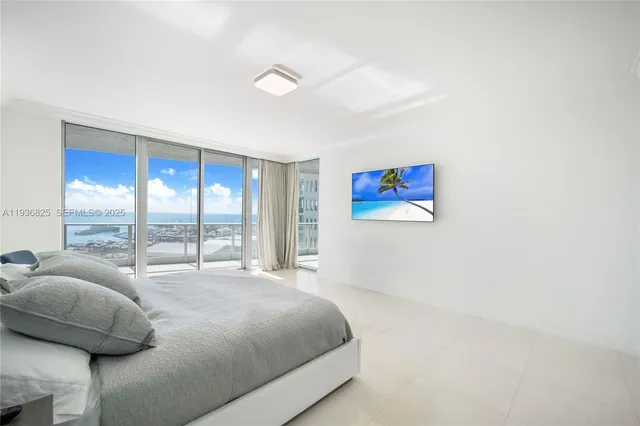 a bedroom with a bed and a large window