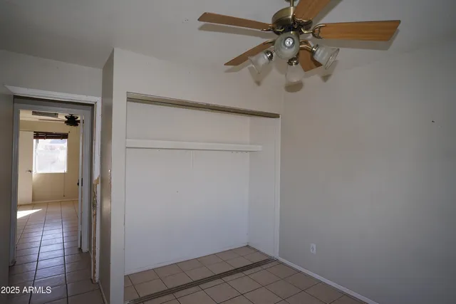 an empty room with a window and a ceiling fan