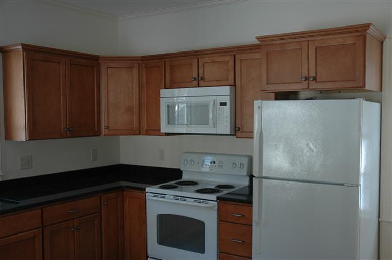 143 Shore Road Bourne, MA 02532 - Photo 12 of 35 a kitchen with a refrigerator stove and cabinets