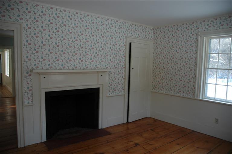 143 Shore Road Bourne, MA 02532 - Photo 22 of 35 a view of an empty room with wooden floor and a fireplace