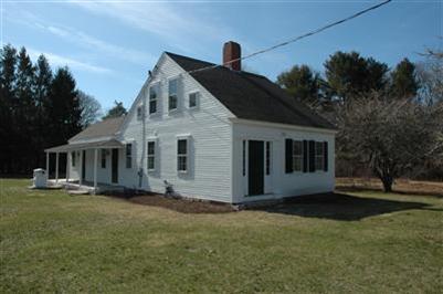 143 Shore Road Bourne, MA 02532 - Photo 3 of 35 a front view of house with yard and trees in the background