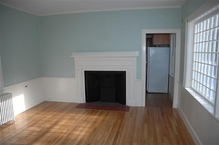 143 Shore Road Bourne, MA 02532 - Photo 7 of 35 a view of an empty room with wooden floor and a fireplace