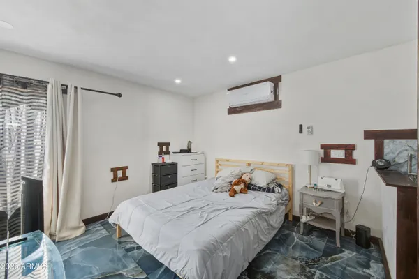 a bedroom with a bed and wooden floor