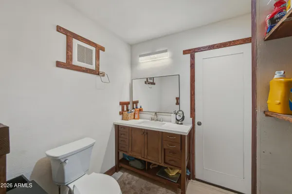 a bathroom with a sink mirror vanity and toilet