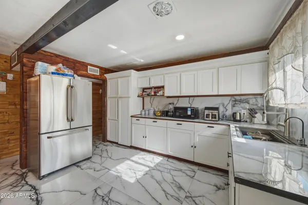 a kitchen with granite countertop a refrigerator and a sink