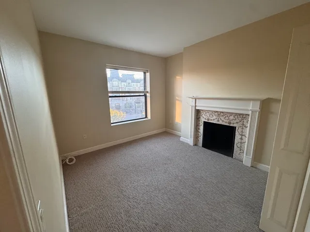 a view of empty room with a fireplace