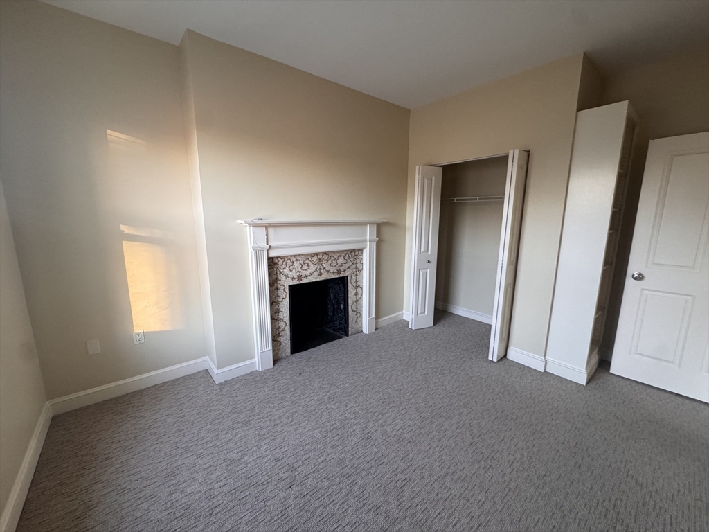 636 Beacon Street, Unit 404 Boston, MA 02215 - Photo 4 of 20 a view of an empty room with a window and fireplace