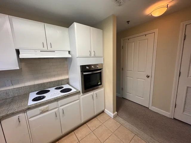 a kitchen with white cabinets and appliances